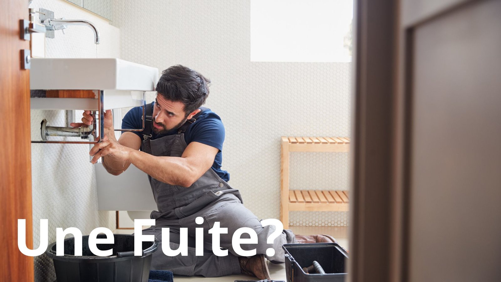 homme qui répare une fuite sous un évier de salle de bain